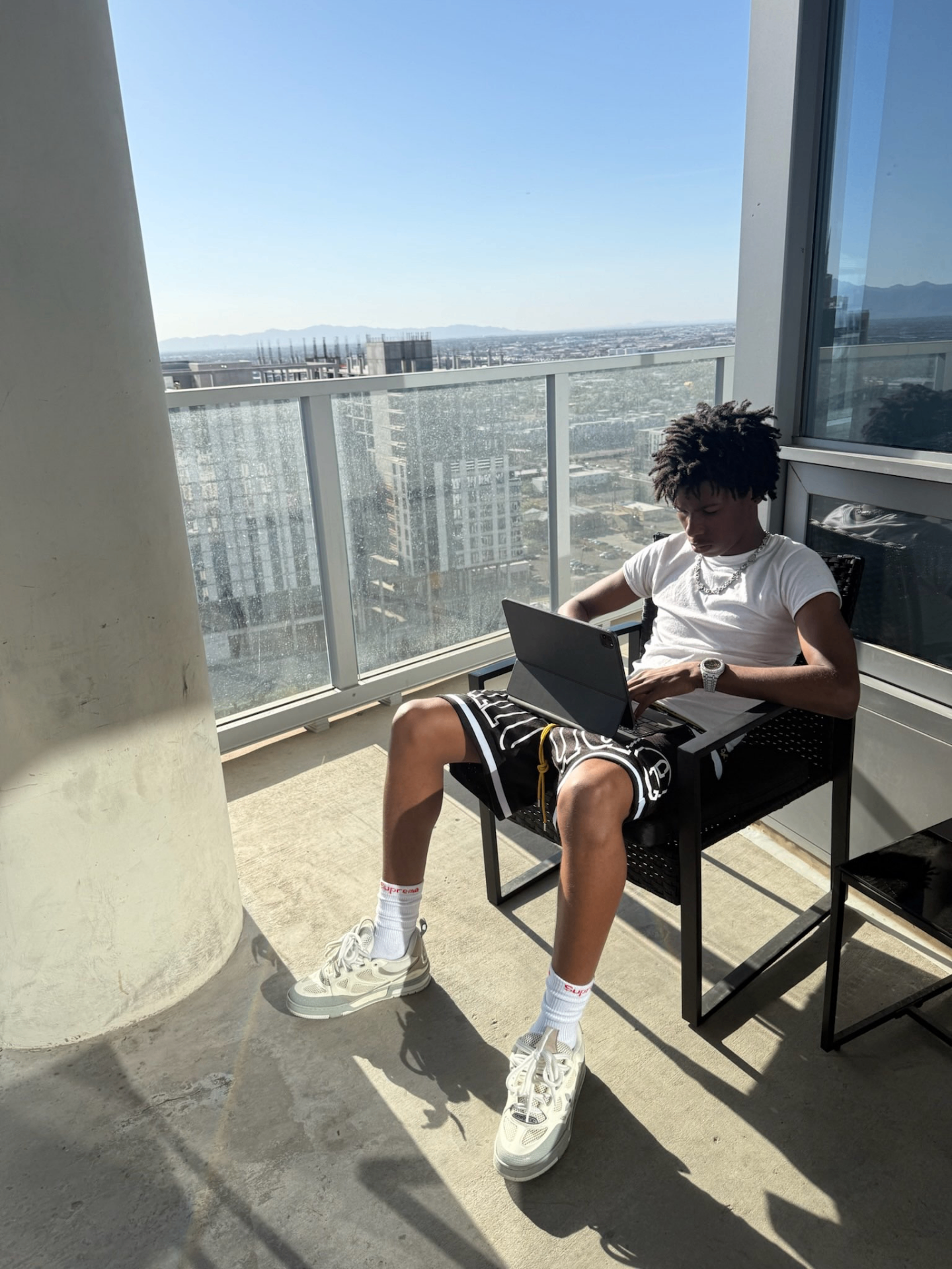 Founder of KM Digital working on a laptop overlooking the city skyline